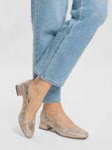 Soft gold leathger shoes worn with light blue jeans on a white background