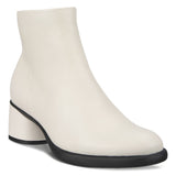 White ankle boot with a black sole on a white background