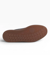 Close-up of a shoe sole with a brown tread pattern on a white background