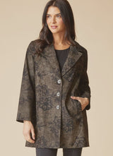 Woman wearing a black floral pattern on an umber colored car coat