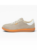 Beige sneaker with white laces and orange sole on a white background