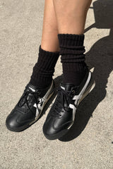 Black sneakers and socks on a concrete surface