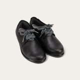 Pair of black leather shoes with gray laces on a light gray background