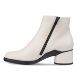 A side-view shot of a white leather ankle boot with a black side zipper, black sole, and a chunky black block heel on a white background.
