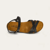 Brown sandal with black straps on a light gray background