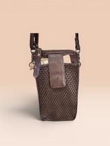 Chocolate brown woven crossbody bag on a beige background