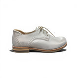 Gold leather shoe with a brown sole on a white background