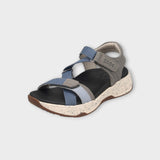 Multicolored sandal with blue, gray, and black straps on a light gray background