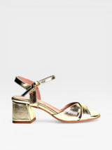 gold sandal with block heel and white background