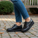 Strada black leather Oxford shoe with a patterned toe cap and lace-up closure. Features a thick platform sole.
