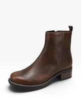 A dark brown leather ankle boot with a low stacked block heel, white contrast stitching, and a black treaded sole, shown from a three-quarters angle on a white background.