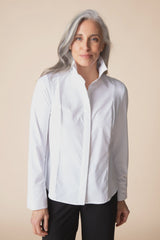 Woman wearing a white shirt against a beige background