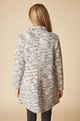 Person wearing a textured long coat on a beige background