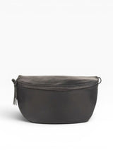 Black leather crossbody bag on a beige background