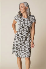 Woman wearing a patterned dress against a beige background