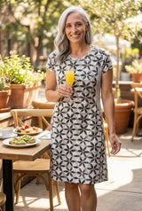 women holding a drink in a black and white textured dress