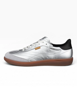 Silver sneaker with black heel and brown sole on a white background