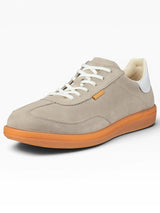 Beige sneaker with orange sole on a white background
