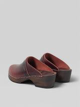 Pair of brown wooden clogs on a white background