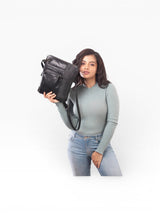 Women holding a black handbag in her right hand