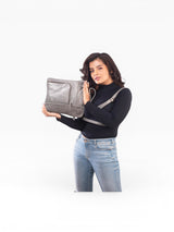 Women holding a grey handbag in her right hand