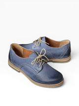 Pair of blue leather shoes with brown soles on a white background