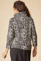 Person wearing a patterned top on a beige background