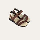 Pair of brown sandals with straps on a light gray background