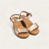 Pair of gold sandals on a light gray background