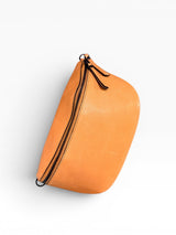 Tan pouch with a black zipper on a light gray background