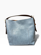 Light blue handbag with brown handle on a white background