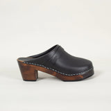 Black leather open back shoe with dark sole against a white background