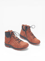 Pair of orange/brown leather boots with black soles on a white background