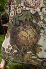 Close-up of a dress with intricate floral and classical design.