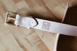 Leather belt with a buckle on a wooden surface