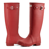 Pair of red rubber boots with buckle details on a white background