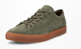 Green suede sneaker with brown sole on a white background