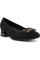 A black suede pump shoe with a low block heel and a decorative metallic buckle embellishment on the toe, shown against a plain white background.