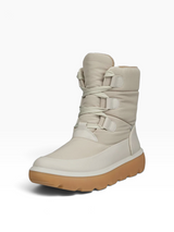 A light beige mid-calf winter boot with thick laces, adjustable straps, and a chunky tan sole, shown on a light gray background.