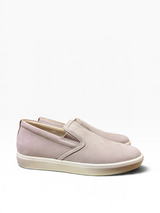 A pair of slip-on loafers in a light dusty pink pebbled leather with a thick cream-colored rubber sole, shown against a plain white background.