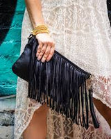Black Bolsa Nova Fringe Handbag with tassel details and adjustable strap, stylish accessory for casual or evening wear.
