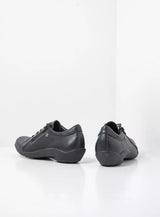 Pair of black leather sneakers on a white background