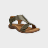 Green sandal with brown sole on a light gray background
