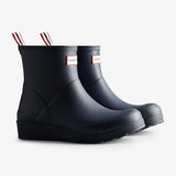 A pair of rubber rain boots with the classic Hunter brand label on the side and red, white, and black pull tabs at the collar, shown on a light gray background.