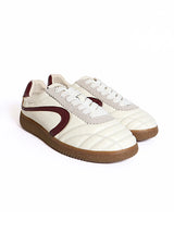A pair of retro-style low-top sneakers in off-white leather with a quilted toe, a dark burgundy side stripe, white laces, and brown gum soles, shown on a plain white background.