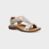 Beige sandal with decorative straps on a light gray background