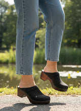 Strada Maguba Berkeley black oiled leather open back clogs with dark wood soles worn with blue jeans outdoors