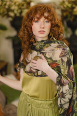Woman wearing a floral and butterfly patterned garment with a blurred indoor background